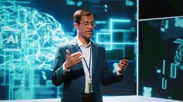 Smiling public speaker hosting AI convention gathering tech startups managers and academics. IT expert moderating symposium, teaching industry workers how to tap into artificial intelligence, camera A video