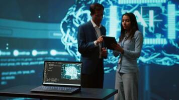 Focus on laptop in workspace used by AI researchers working with artificial intelligence in blurry background. Close up of notebook used by employees developing AI systems in tech startup, camera A video
