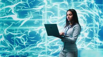 Software developer solving tasks on laptop, running artificial intelligence programming scripts. Woman using notebook to write lines of code for AI applications development, camera A video