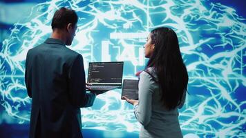 Programmers using devices and AI neural networks modeled after human brain to solve complex problems. Workers using artificial intelligence deep learning to look at data and complete tasks, camera B video