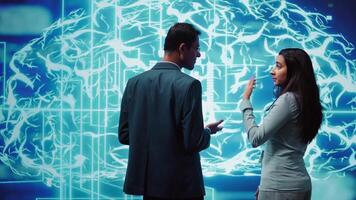 IT staff members using artificial intelligence computing simulating human brain thought processes. Coworkers building AI machine learning algorithms in futuristic workspace, camera B video