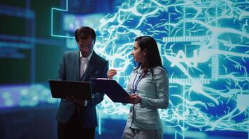 AI researcher and coworker working with artificial intelligence neural networks. Computer scientists collaborating on developing AI system in high tech workspace, camera B video