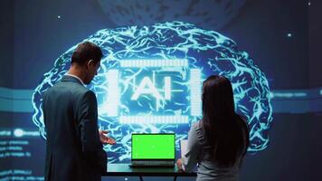 AI developers using isolated screen device for business data analysis. IT department staff members work on chroma key notebook to automatize tasks using artificial intelligence, camera B video