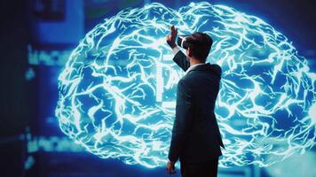 Computer scientist wearing VR headset looking at hologram of artificial intelligence human brain simulation. Indian man interacting with AI visualization showing machine learning algorithms, camera B video