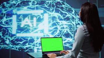 Startup employee looking over charts, using AI software on green screen laptop to take data driven decisions. Indian woman developing innovative artificial intelligence solutions for company, camera B video