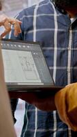 Vertical Real estate agent advising clients on office relocation and leasing, reviewing detailed blueprints and discussing the architectural design of the new property. Contract negotiation. Camera A. video