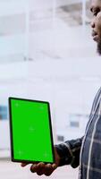 Vertical Real estate agents and client examine blueprints next to a green screen, working together on new modern office space development layout. Sharing workspace design vision. Camera A. video
