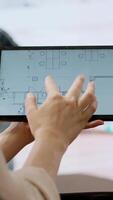 Vertical Real estate agent and client evaluating blueprints and discussing the architectural layout of new office space during office tour. Businessman strategizing corporate office relocation deal. Camera A. video