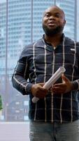 Vertical Real estate broker and client analyzing blueprints for an office space, evaluating the property and reaching a contract agreement. Businessman planning an investment strategy. Camera A. video