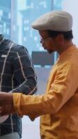 Vertical Entrepreneur evaluating an investment opportunity in real estate, reviewing blueprints on tablet and discussing the architectural plans of the new office space with the realtor agent. Camera B. video