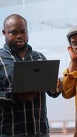 Vertical Real estate agent presenting a new office building to clients, discussing the detailed blueprints using a tablet during the property tour. Potential leasing investment opportunity. Camera B. video