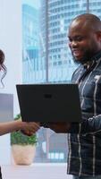 Vertical Realtor broker showing architectural blueprints on laptop to business team potential clients, presenting high class building space during tour. Offering insurance and legal assistance. Camera B. video