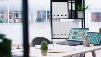 Empty company financial department with stock portfolio on laptops containing collection of investment assets. Workspace with live index indices on notebook screen showing stock demand surge video