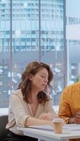 Vertical Real estate brokers meeting with client to reach an agreement for property leasing contract, evaluating urban property blueprints and negotiating terms for a high class corporate building. Camera B. video