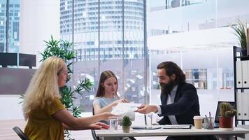 Financial advisor discussing with customers, recommending optimal insurance policies. Agent informing parent and daughter of best investment strategies, offering statistics, camera A video