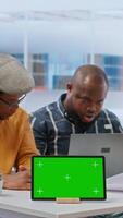 Vertical Businessman discussing with the real estate agents next to chroma key on tablet, meeting to negotiate leasing contract terms before looking at blueprints for an office relocation. Camera A. video