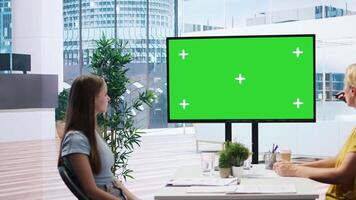 Financial adviser presents market analytics on green screen display to clients, teaching them how to build portfolio. Broker showing stock exchange charts on mockup device to family, camera A video