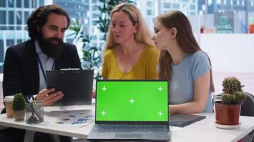 Financial advisor showing data graphs on green screen notebook to customers, analyzing market trends to do forecasting. Clients checking investment plan on chroma key laptop, camera A video