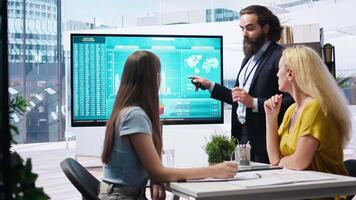 Financial adviser presents market analytics to customers using large display, emphasizing data driven decision making. Broker agent showing statistical graphs about stock exchange shares, camera A video