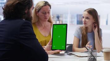 Broker holding green screen tablet, meeting with clients to provide stock exchange analysis. Financial advisor with chroma key device looking at market shares, helping family maximize income, camera B video