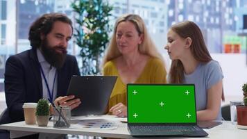 Financial advisor showing data graphs on green screen notebook to customers, analyzing market trends to do forecasting. Clients checking investment plan on chroma key laptop, camera B video
