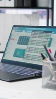 Vertical Stock market values going up and down on laptop in empty financial department office, price volatility concept. Forex trading economic analytics figures on notebook screen in workspace video