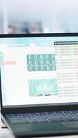 Vertical Stock portfolio on laptop containing investment assets affected by market volatility. Empty workplace with live index indices on notebook screen showing stock demand surge, close up video