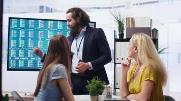 Financial adviser presents market analytics to clients using large screen, emphasizing data driven decision making. Broker showing statistical charts about stock exchange indicators, camera B video