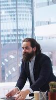 Vertical Portrait of cheerful financial advisor in office meeting with parent and child to provide personalized spending planning. Jolly agent in workspace doing handshake with customers, camera A video