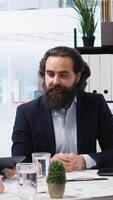 Vertical Broker investor in office offering financial advice to clients, calculating their stock exchange profits. Financial advisor looking at market shares growth with customers, camera A video
