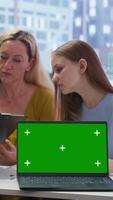 Vertical Financial adviser assisting clients in setting up investment accounts with isolated screen laptop, close up. Consultant uses financial planning software on chroma key notebook to help family, camera B video