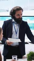 Vertical Financial adviser conducting audit of clients financial situation to strategize plan helping them reach economic goals. Agent offering advice on budgeting, investing and stock market, camera A video