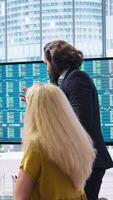 Vertical Broker in office providing stock exchange valuation analysis for clients looking to make more money. Financial advisor looking at market shares on big screen, helping people make investments, camera A video
