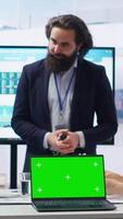 Vertical Financial adviser presents market analytics on isolated screen laptop to clients, teaching them how to build portfolio. Broker showing stock exchange charts on chroma key notebook to family, camera B video