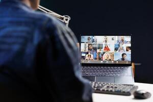 Engaged group of individuals, including African American person, utilizing technology for virtual communication. They are working remotely, attending online meetings or classes in a cozy home office. photo