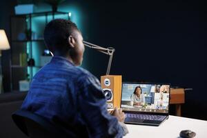 Black woman making call with group of colleagues on a digital laptop. Attending conference meetings and webinars via portable computer as an African American female freelancer. photo