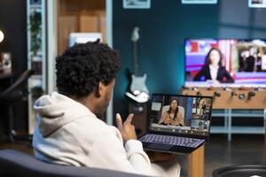 African american man and coworkers in teleconference crosschecking analytics statistical data sets from apartment office. Remote worker optimizing KPIs with colleagues in videocall photo