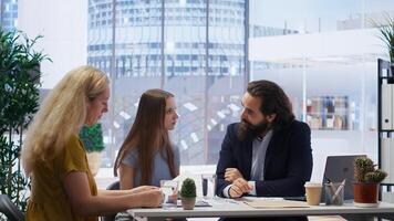 Financial adviser providing customers with informative leaflets on budget management. Consultant in office assisting family members in setting up investment accounts, camera B photo