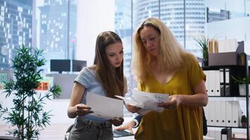 Clients looking over statistical charts given by financial advisor analyzing market trends and providing informed recommendations to optimize their income. Women reading investment plan, camera A photo