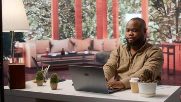 Freelancer conducting business analysis and managing online communication, working from home. Self employed man developing a startup using his laptop for strategic planning. Camera A. photo