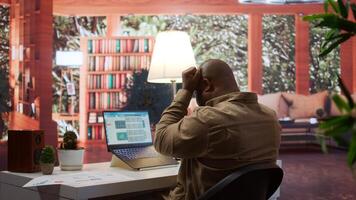 Business analyst calculating project funds and analytics at his home, allocating resources and solving tasks to accomplish objectives. Entrepreneur works on money management accounting. Camera B. photo