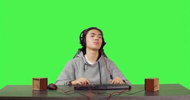 POV of person plays pc videogames at workstation, sitting on office chair over greenscreen. Modern guy having fun online with colleagues in rpg competition, wearing headset at his desk. photo