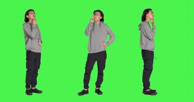 Young thinker acting uncertain on camera, thinking about question and putting his concentration on new perspective. Adult being doubtful and confused, pondering over greenscreen template. photo