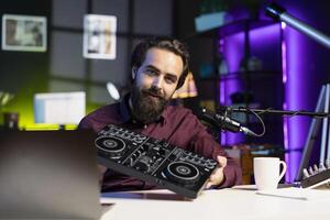 Content creator filming technology review, recommending newly launched DJ controller. Influencer advocating for high quality sound mixer device in front of followers after testing it photo