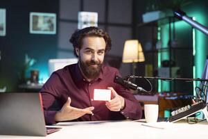 Portrait of smiling tech guru filming technology review of mini led lights, unboxing it for audience. Cheerful internet star showing filming equipment to subscribers, talking in mic photo