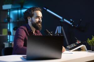 Smiling media star using professional recording equipment to film vlog channel intro for online streaming platforms. Cheerful man greets viewers, presenting today topic photo