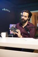 Tech content creator filming technology review of newly released V mount battery, analyzing it before giving opinion on specifications to audience. Media star showing charging device to subscribers photo