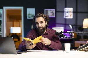 Knowledgeable media star reading and recommending best reviewed books of the year. Influencer in studio doing novel summaries for interested readers, speaking in professional microphone photo