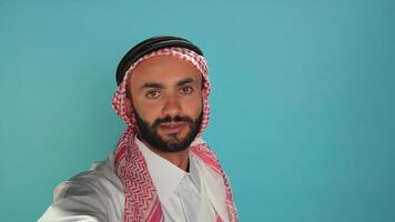 POV arab person on videocall conference, waving at people on online internet connection. Middle eastern man with headscarf meeting with friends on remote videoconference network. Handheld shot. photo
