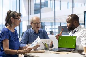 Elderly pair meeting with a financial broker next to copy space display, exploring retirement plan options and ensuring their pension for the future. Finances planning strategy. photo